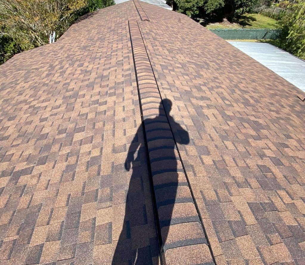 Top view of a house roof with the shadow of a man on it